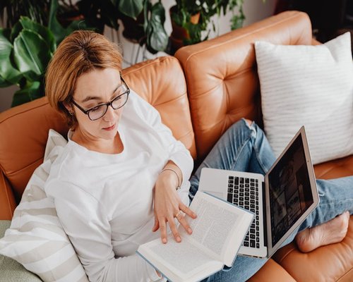 person reading a book on a comfortable sofa resting from work