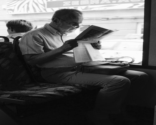 commuter reading a book peacefully on a bus