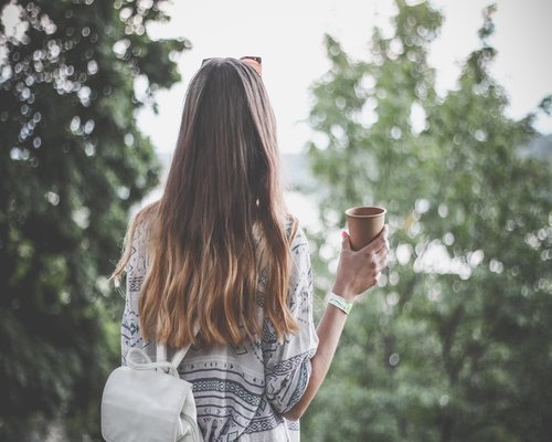 young mexican woman relaxing in an urban park with coffee